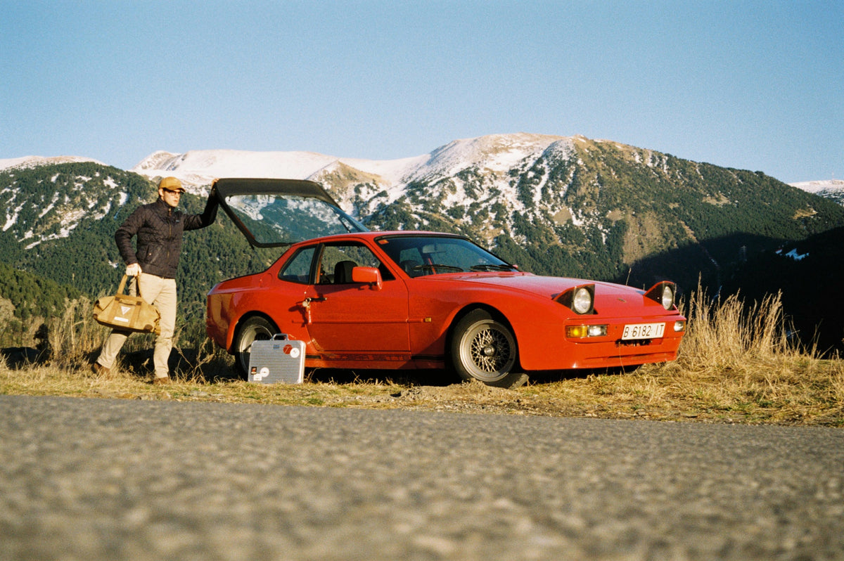 A red Porsche beside a mountain road